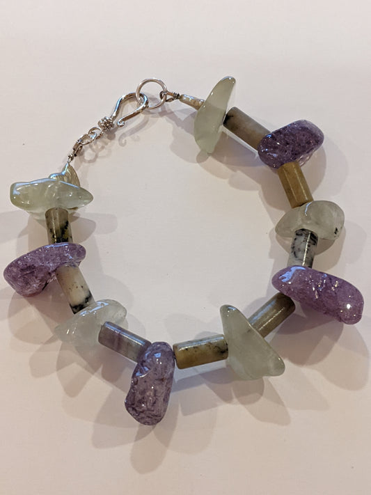 Beaded bracelet on white  background.  Bracelet is crafted from amethyst and green aventurine nuggets with stone tube beads between.  Bracelet has a silver hook & eye clasp.