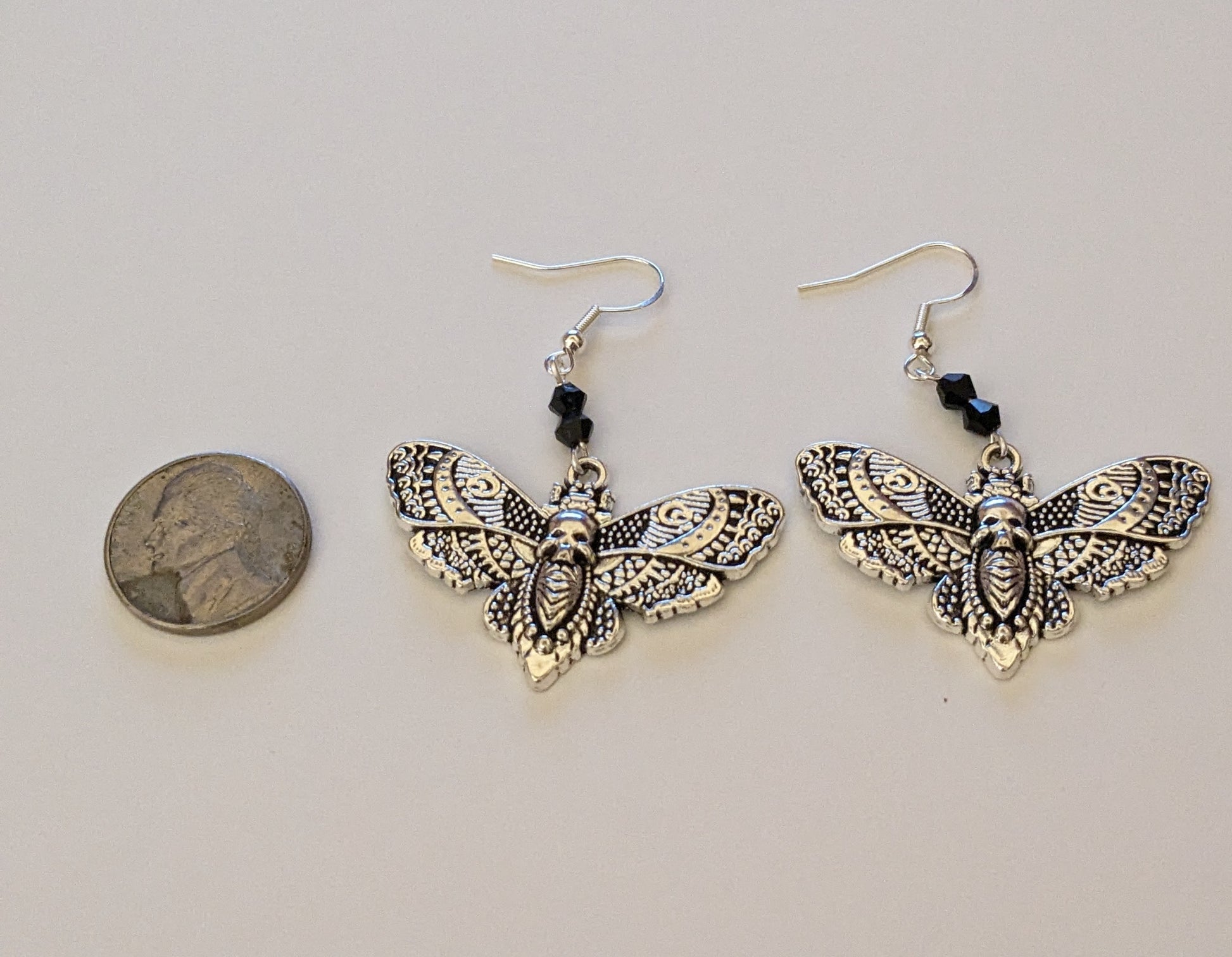 Earrings next to a nickel to show scale 