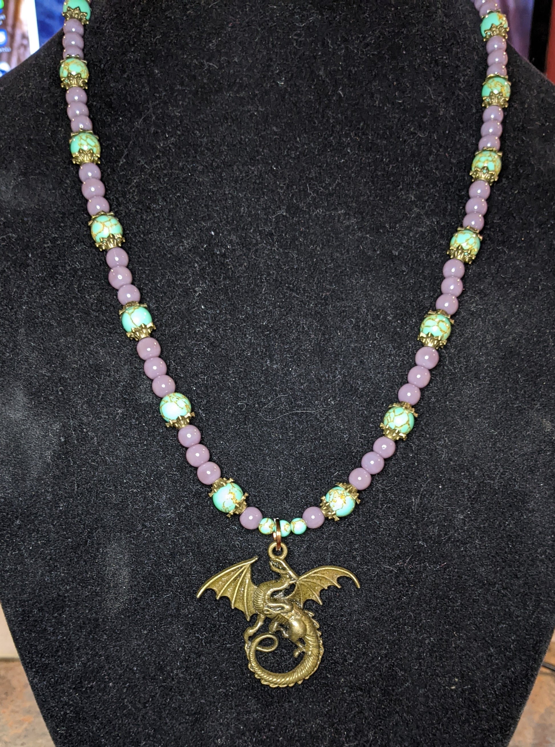 Purple and blue beaded necklace with a bronze dragon pendant 